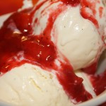 strawberry topping added to ice cream