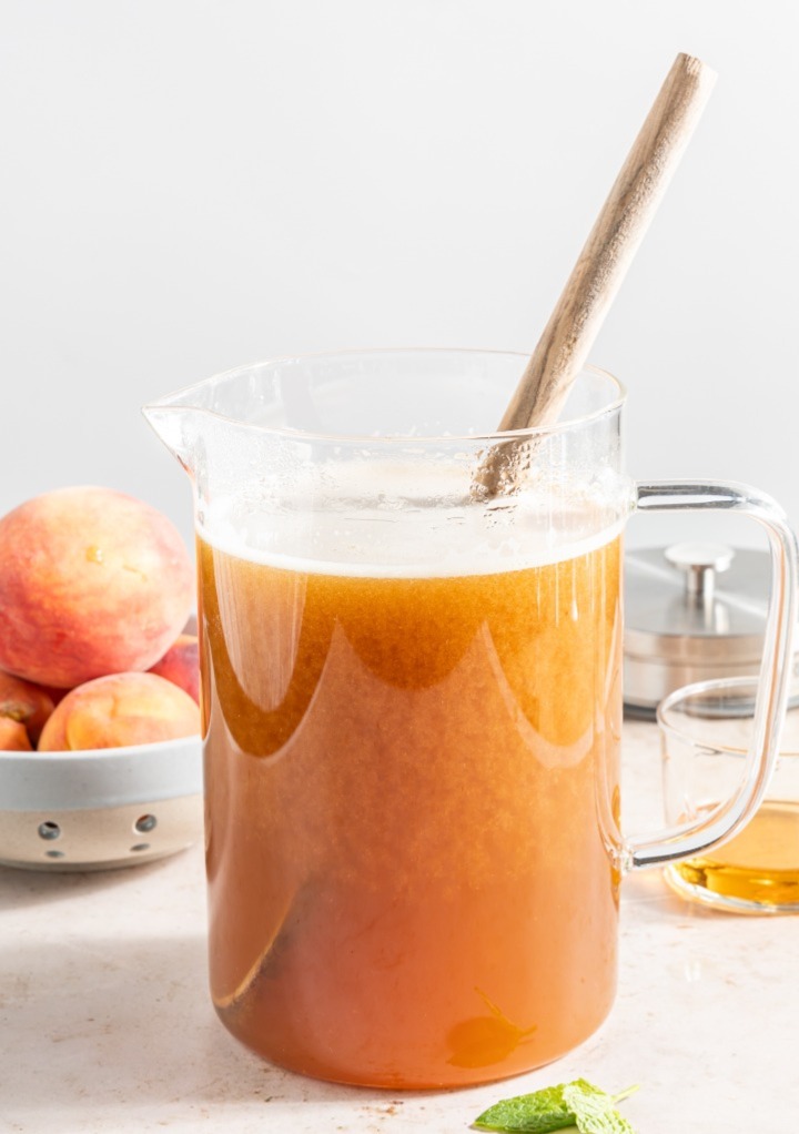 Peach puree mixed with brewed tea in a glass pitcher. 