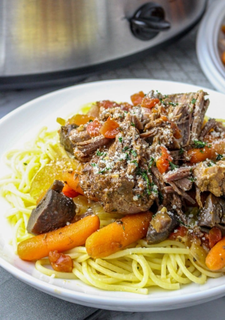 Pot roast with carrots over a bed of spaghetti ready to eat. 