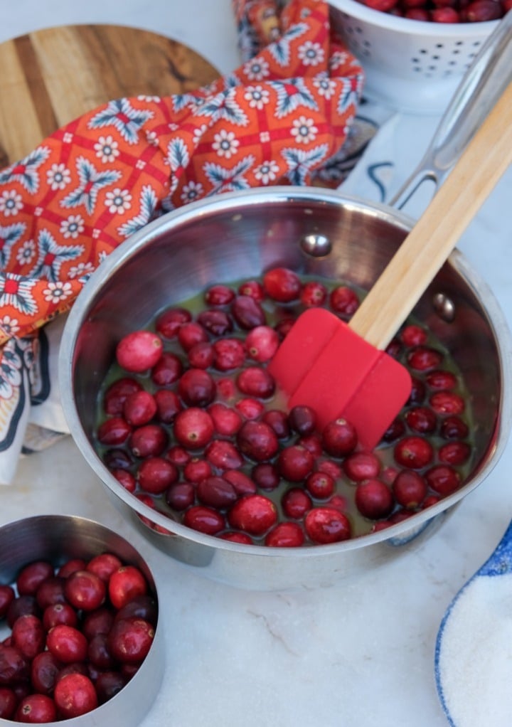 Fresh cranberries in a small saucepan with orange juice. 