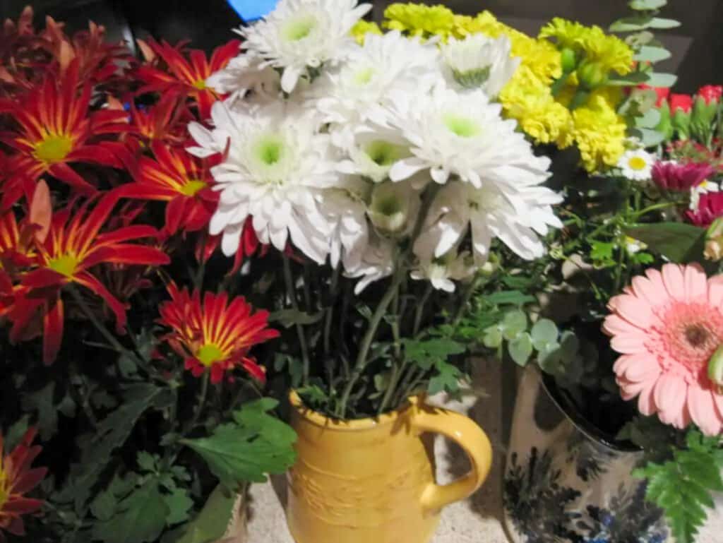 Fresh flowers in different containers to make a floral arrangement. 