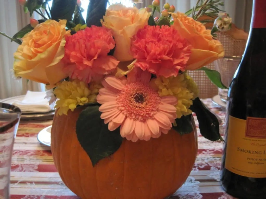 Floral pumpkin centerpiece on a table for display. 