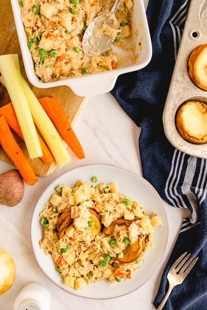 Top view of healthier chicken pot pie casserole dish with a serving on the side of the white dish.