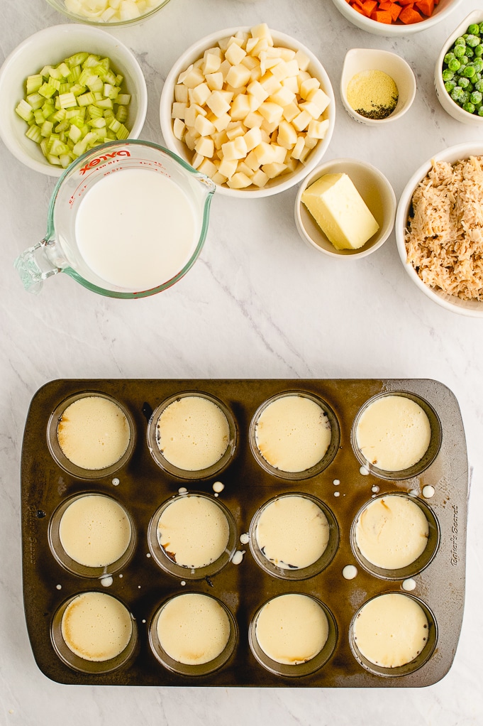 Popovers in a muffin pan ready to bake. 