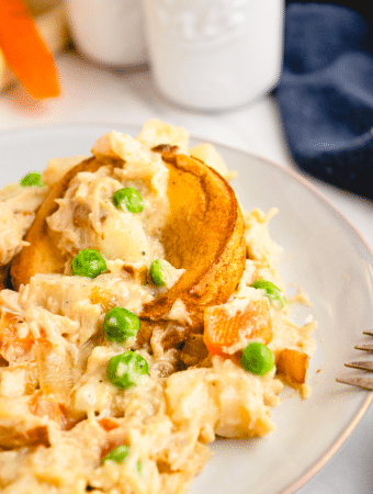 Chicken pot pie on a white plate ready to enjoy eating.