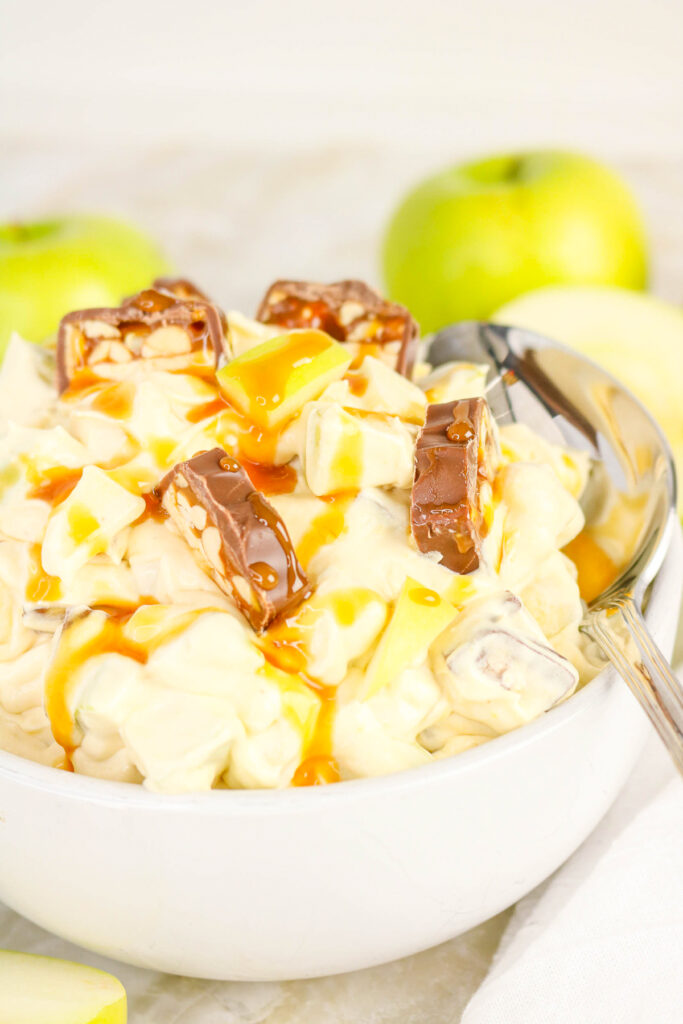 Apple snickers dessert salad in a white serving bowl.