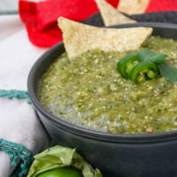 Green salsa made with tomatillos with tortilla chips.