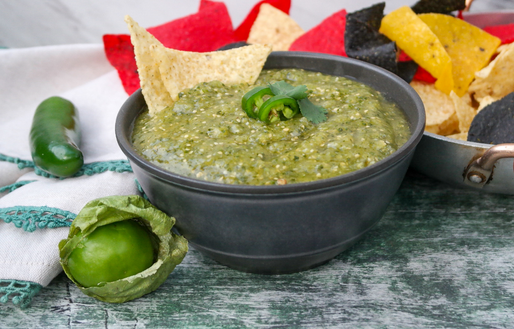 Green salsa made with tomatillos with tortilla chips dipped in the sauce. 
