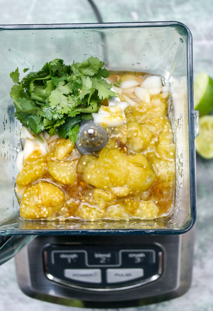 Ingredients to made green salsa in a blender. 