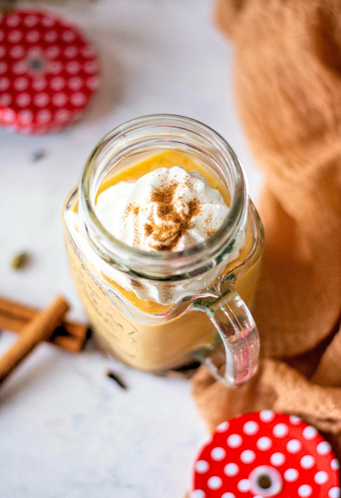 A top view of a pumpkin smoothie topped with whipped cream. 