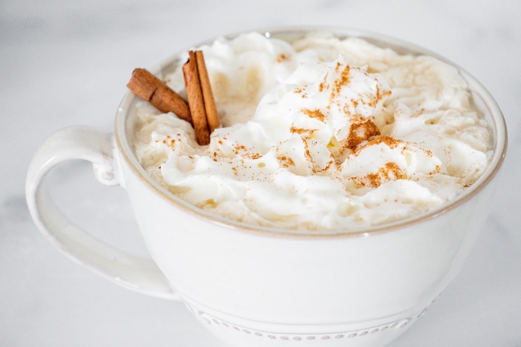 A white mug with pumpkin spice latte. 