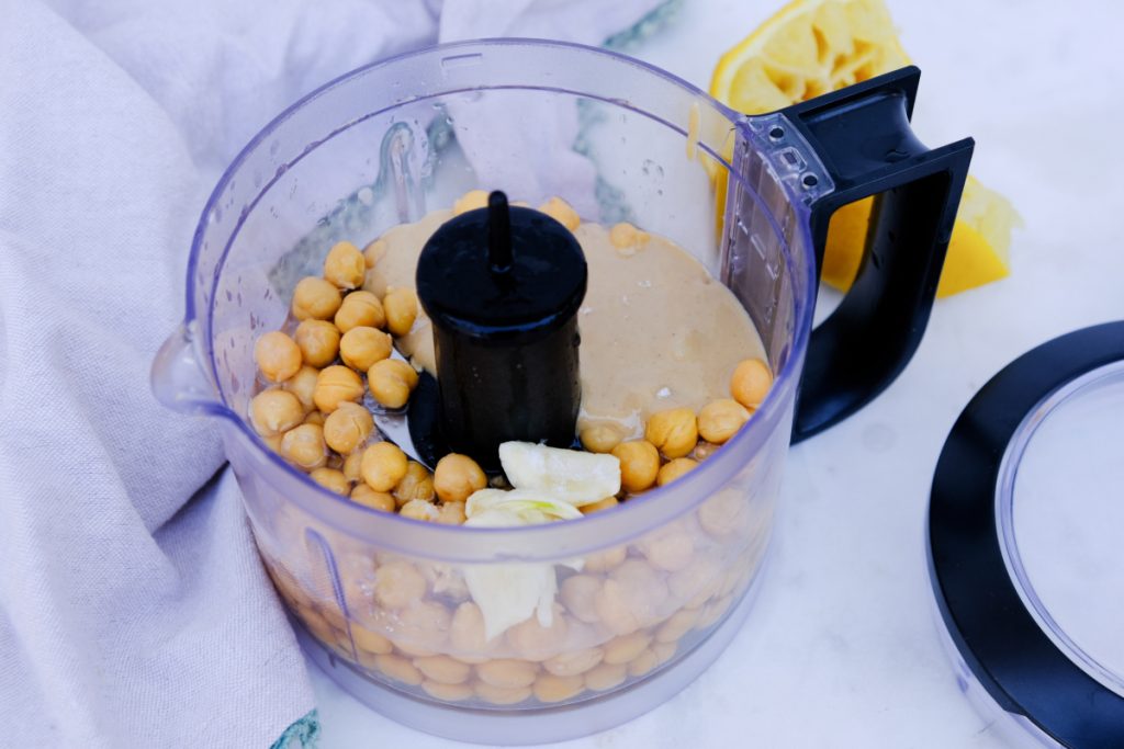 Ingredients to make hummus in a small food processor.