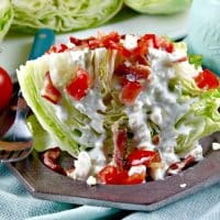 Wedge salad topped with blue cheese dressing and tomatoes