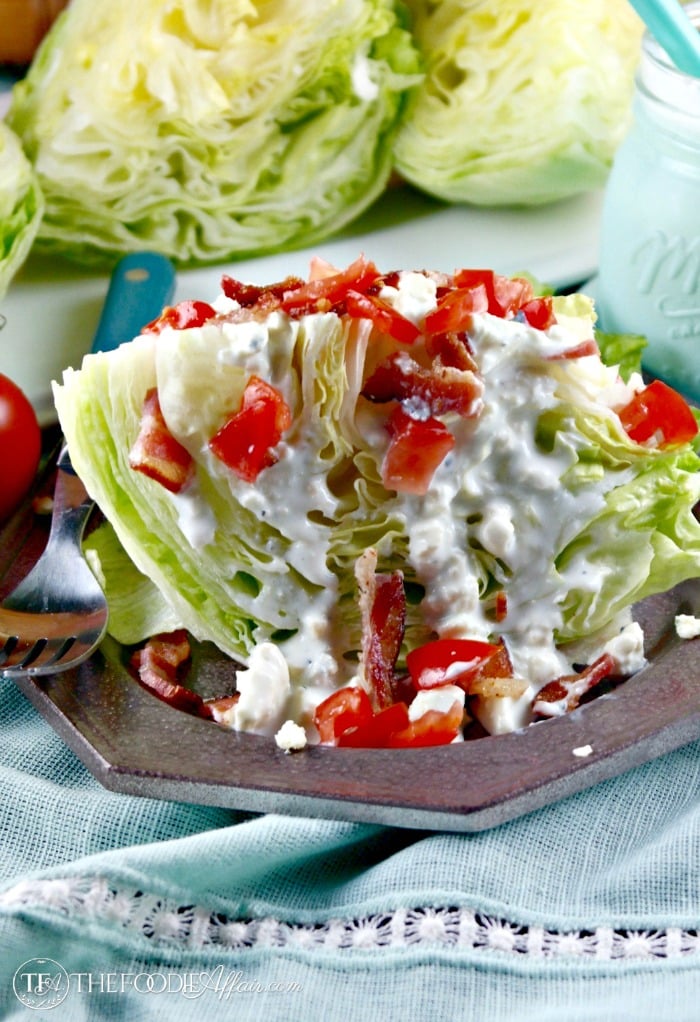 Wedge salad topped with blue cheese dressing and tomatoes