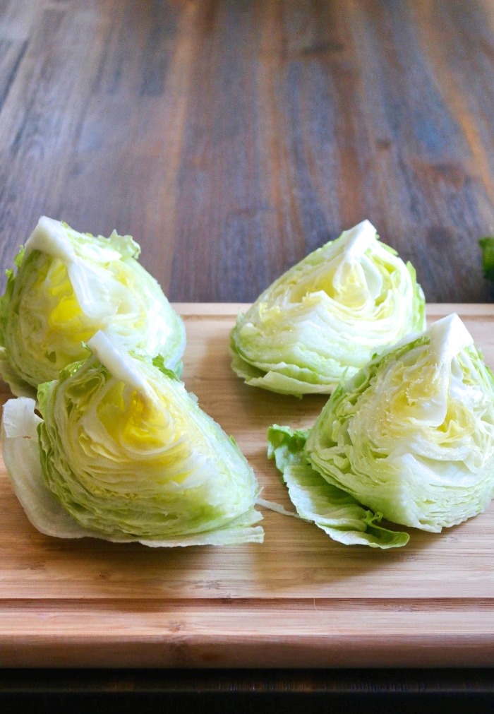 Four lettuce wedges on a cutting board