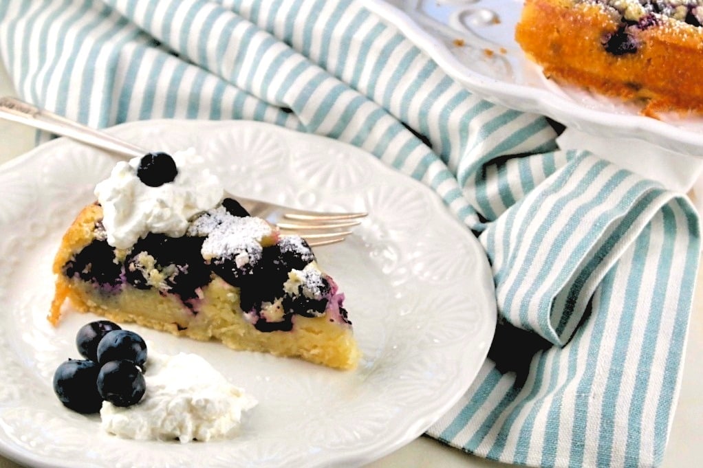 horizontal view of blueberry coffee cake on a small white plate