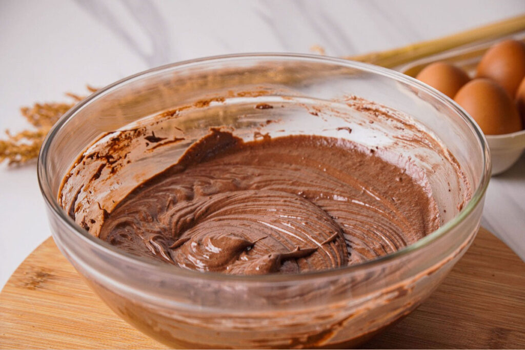 Chocolate cupcake batter in a clear mixing bowl before baking. 