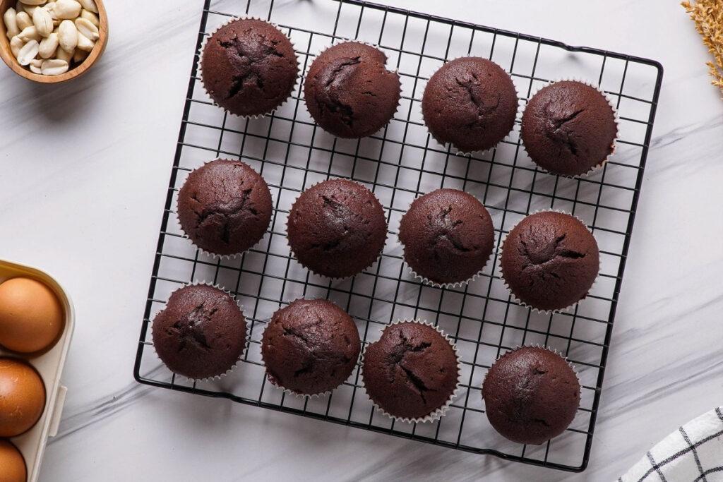 Chocolate cupcakes on a baking rack cooling. 