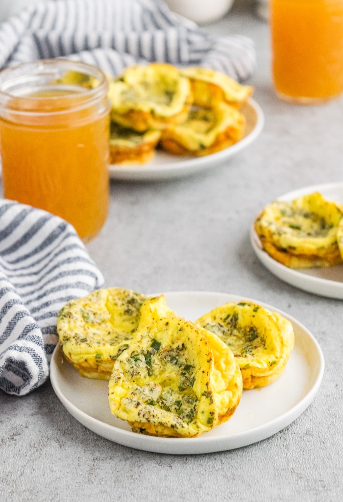 Two serving plates filled with egg muffin cups made with sour cream and chives. 