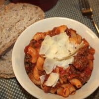 macaroni and beef pasta dish in a white rimmed bowl.