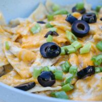 A blue skillet with a cooked enchilada dish.