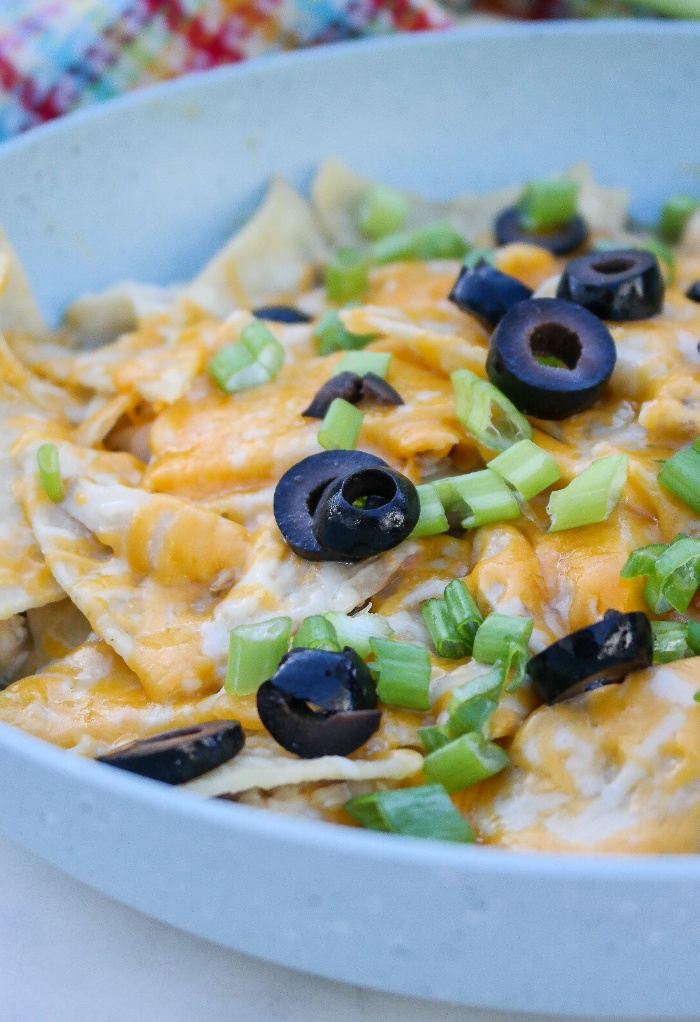 A blue skillet with a cooked enchilada dish.