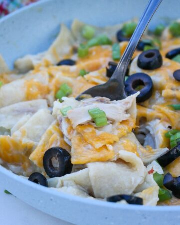 Enchiladas made in a skillet topped with cheese.