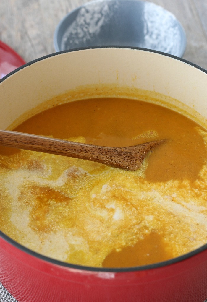 Sweet potato soup with coconut milk being added to the recipe. 