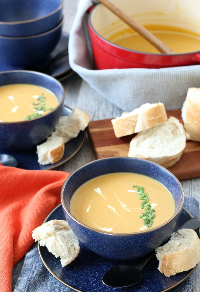 Finished sweet potato soup with coconut milk in a bowl with some bread on the side. 