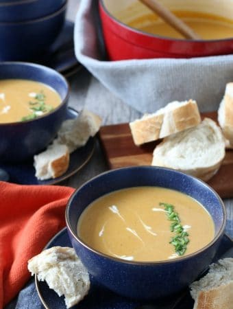 Sweet potato soup with curry finished and ready to be eaten, dished out into bowls with bread.