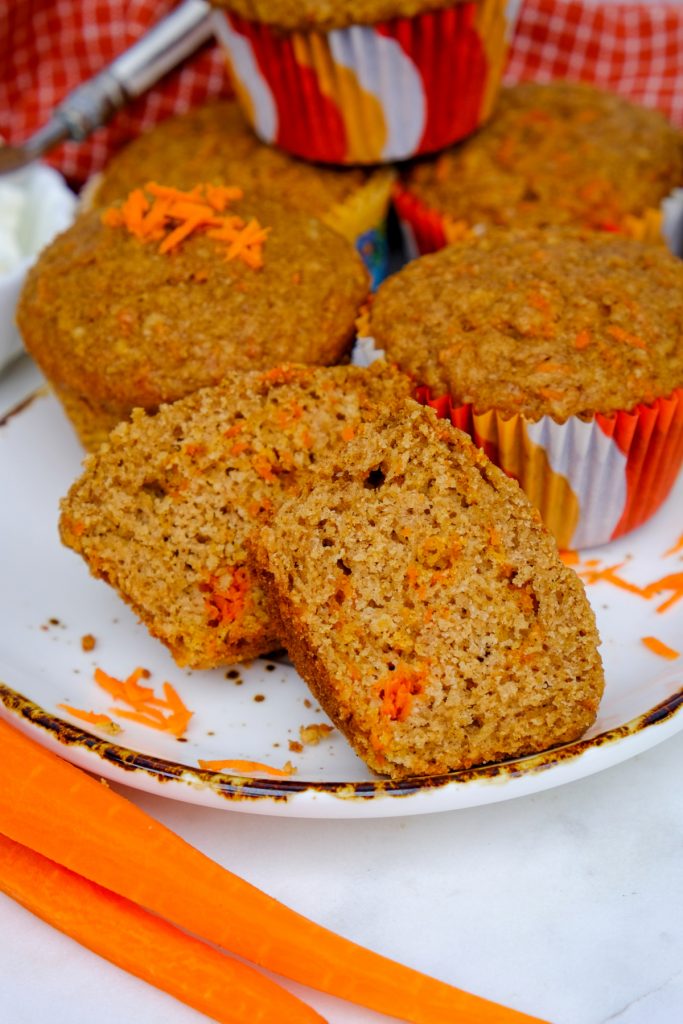 A muffin sliced in half on a white serving plate. 