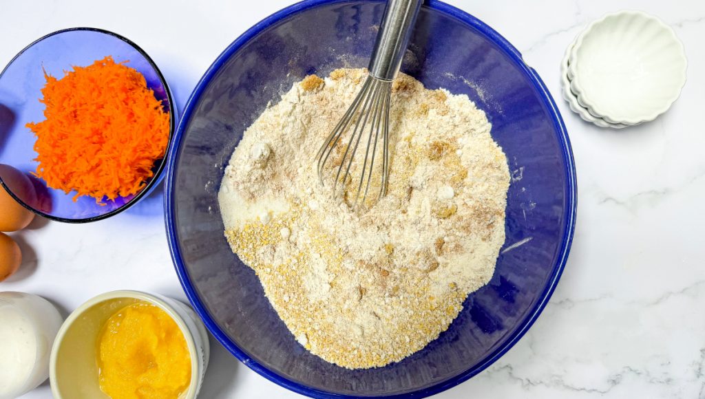 Dry ingredients for muffins in a blue mixing bowl. 