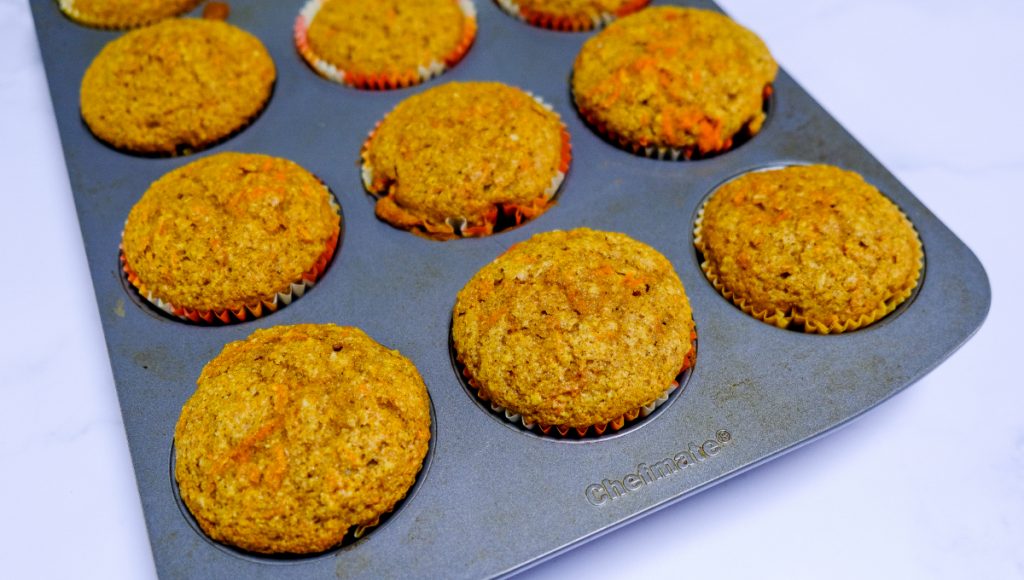Baked carrot cake muffins in the tin cooling. 