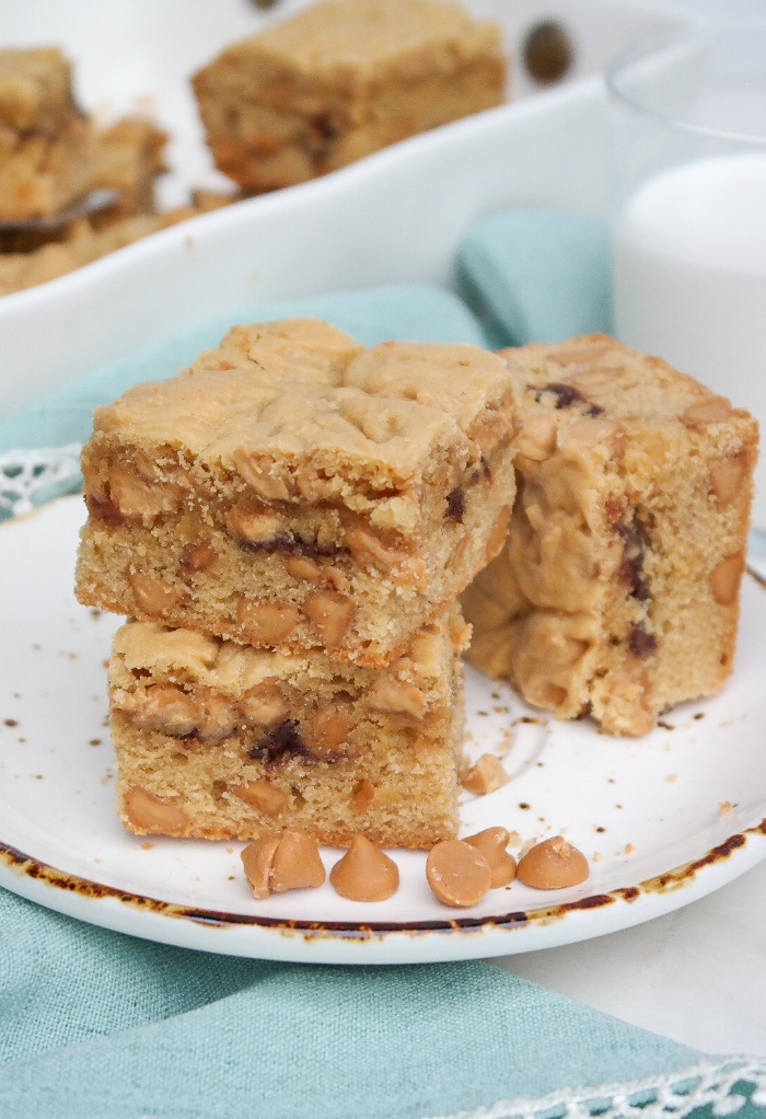 Sliced cookie bars on a plate with milk on the side. 