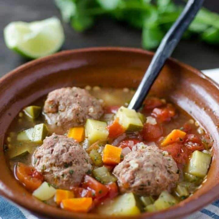 Albondigas soup with vegetables in a brown bowl