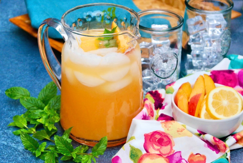 Clear pitcher of lemonade made with fresh peaches