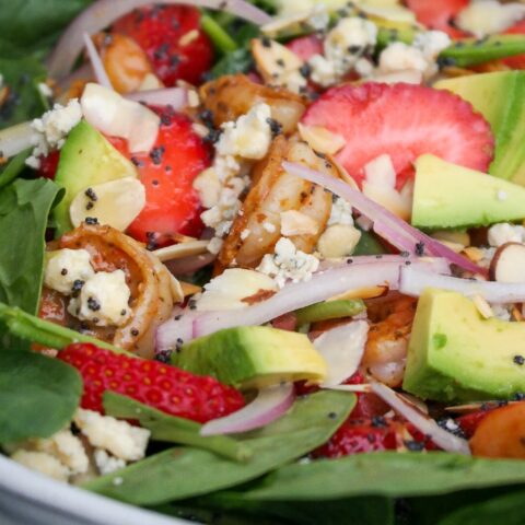 Close view of spinach salad with shrimp and strawberries.