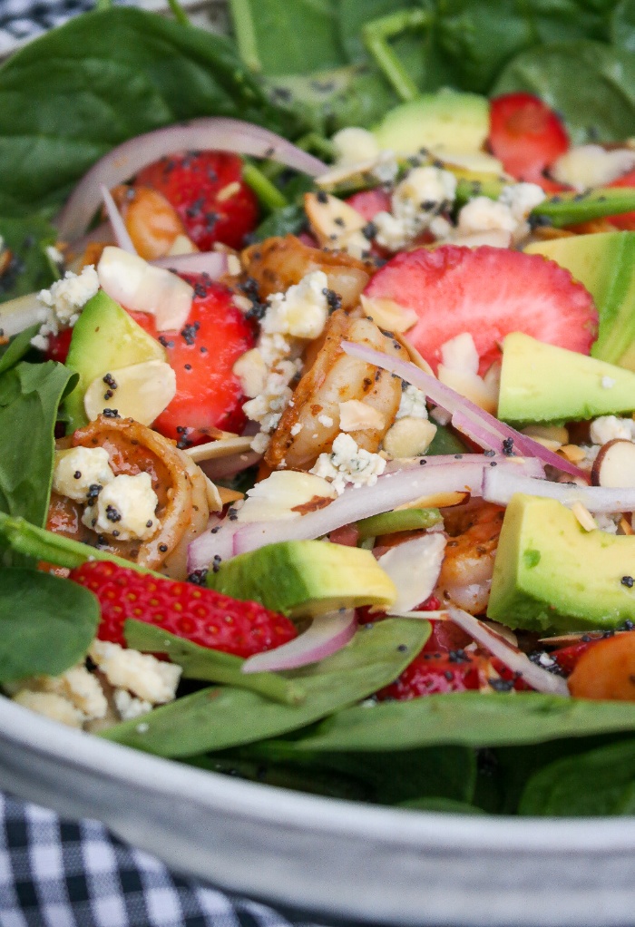 Close view of spinach salad with shrimp and strawberries. 