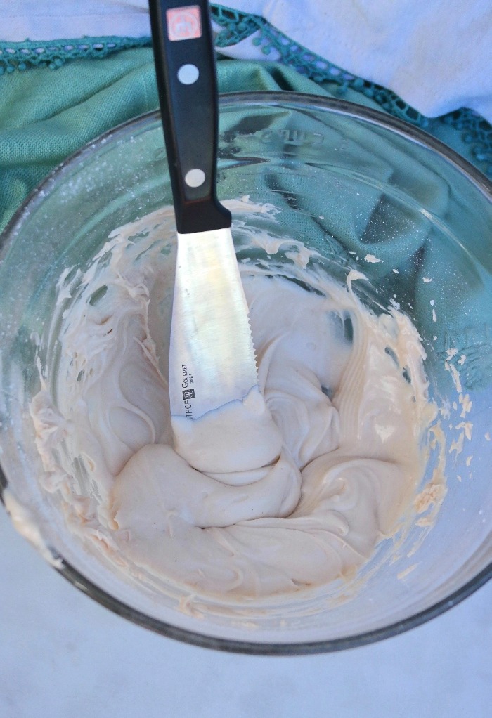 Icing in a clear bowl made with browned butter. 