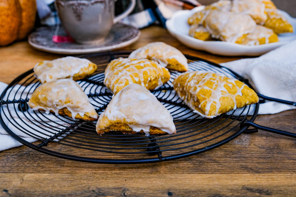 Scones with a light drizzle on a black cooling rack. 