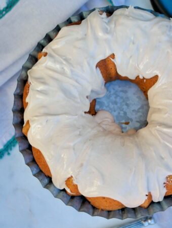 Top view of a spice cake with icing ready to be sliced.