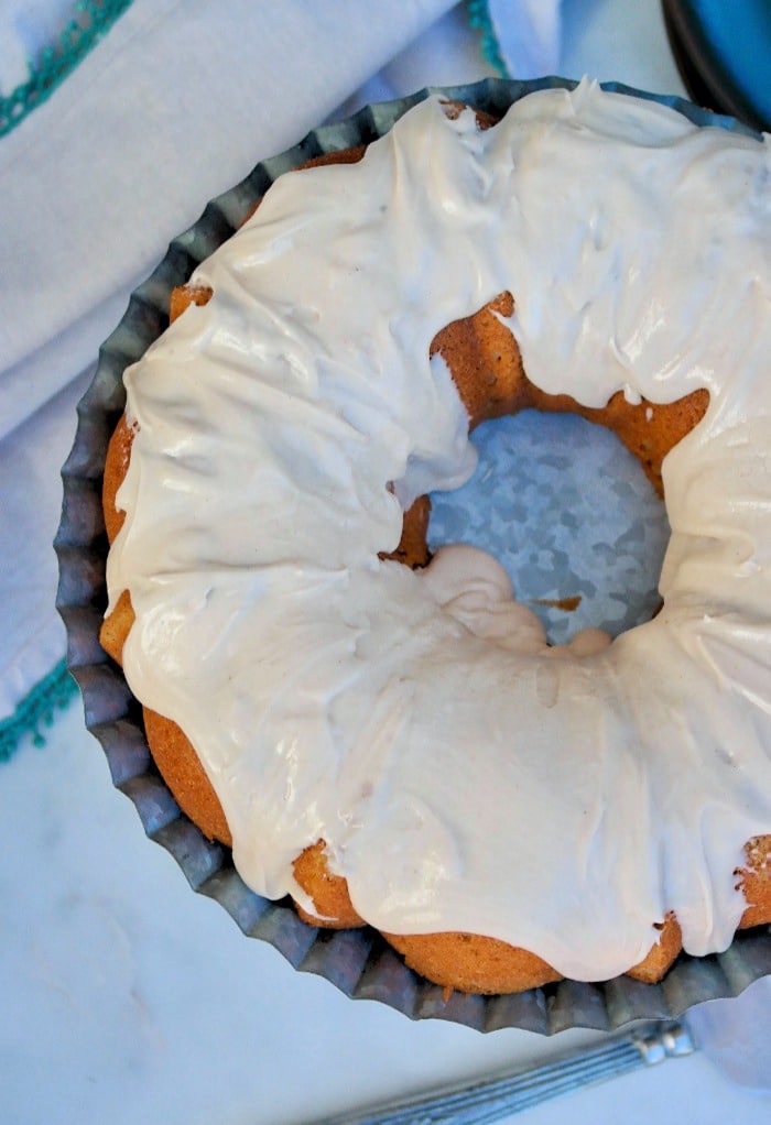 Top view of a spice cake with icing ready to be sliced.