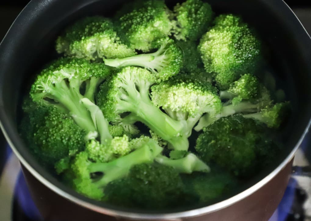 Fresh broccoli florets for broccoli cheddar soup recipe in a pot