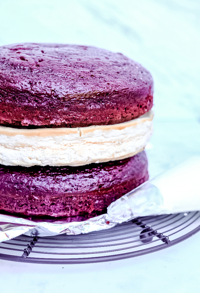 Three layered red velvet cheesecake recipe ready to frost.