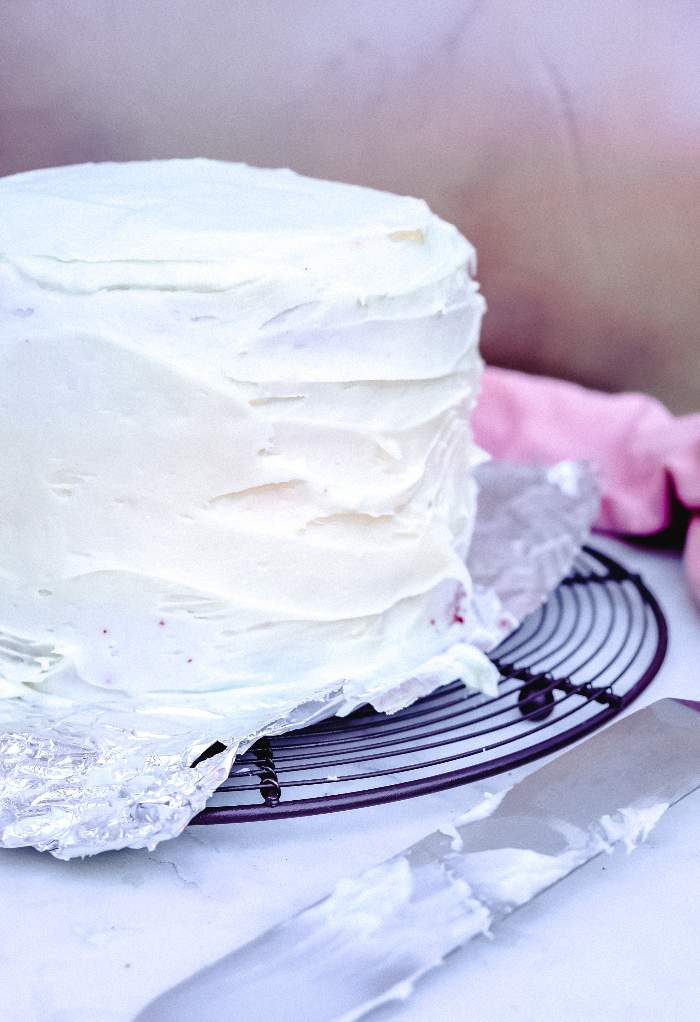 Three layered cake with cream cheese frosting ready to decorate.