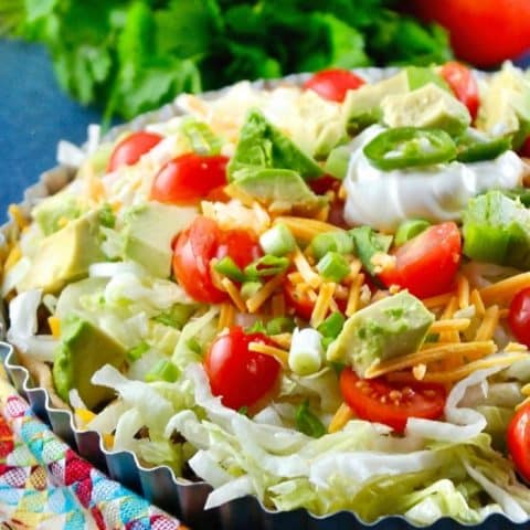 taco pie topped with lettuce and tomatoes