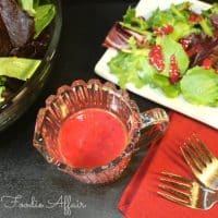 Bright cranberry vinaigrette dressing in clear bottle