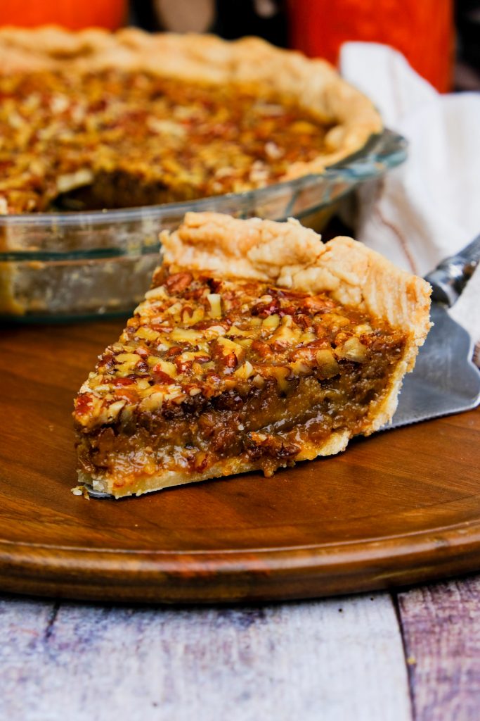 A slice of pie on a brown serving plate. 