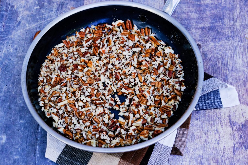 Toasted chopped pecans in a skillet.