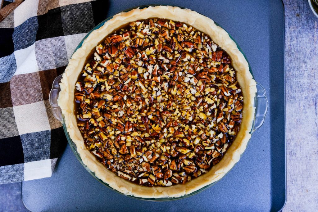 Pecan pie filling in a pie crust before baking. 